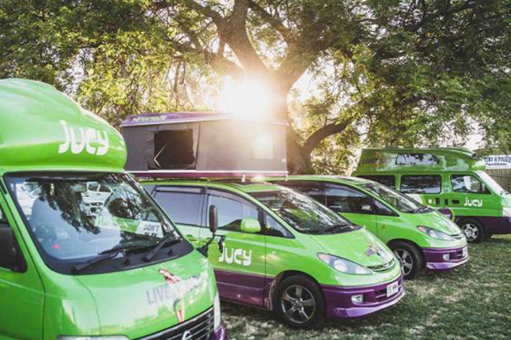 jucy campervans lined up at music festival in australia