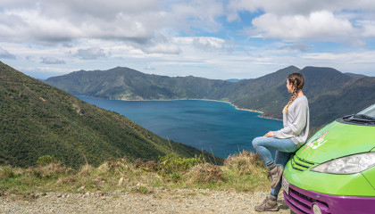 A girl looking at nature outside her JUCY campervan