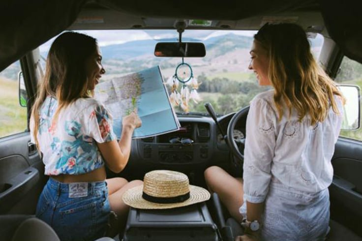 2 girls looking at a map in a campervan