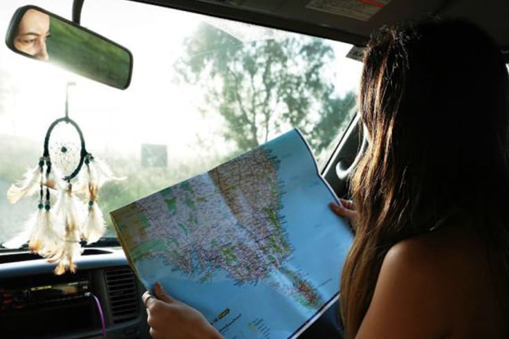A girl looking at a map in a campervan