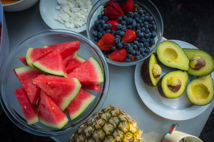 A selection of fruit and avocados on a camping table