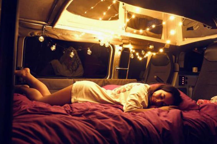 Girl laying on a bed in a campervan