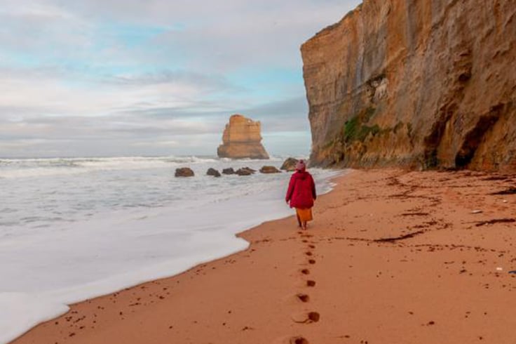 girl walks down beach on great ocean road