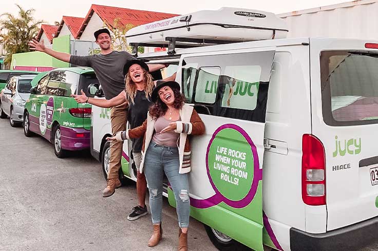 Three excited friends picking up their JUCY Compass Campervan at the JUCY Brisbane Branch