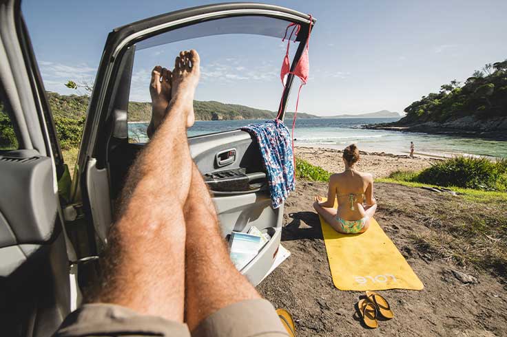 Man with legs on car door