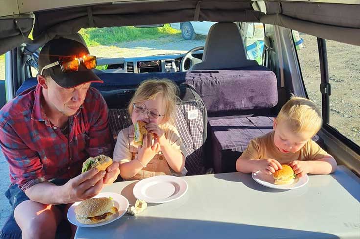 Young family eating lunch and the JUCY Condo Campervan table