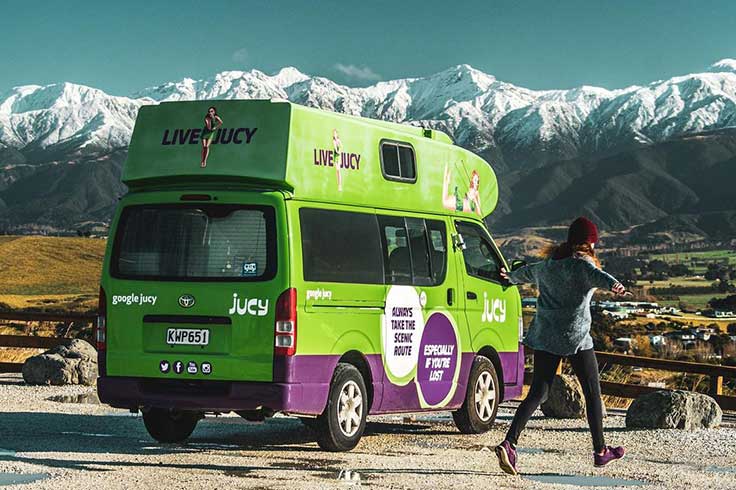 Girl posing beside JUCY Chaser Campervan in Kaikoura for her #JUCYmoments entry