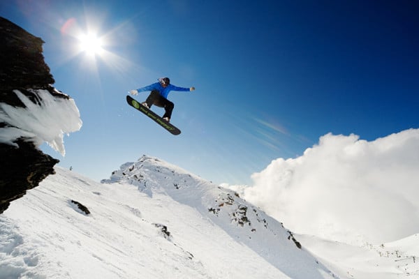Person snowboard jumping on ski slopes New Zealand