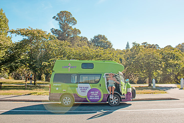 Girl getting out of JUCY campervan