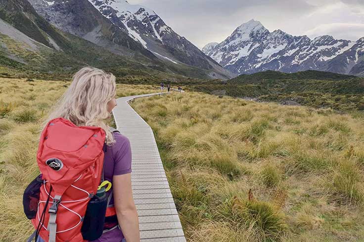 Girl with backpack, walking along Hooker Valley track