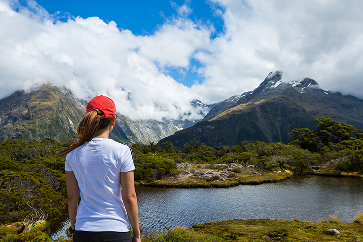 Girl looking out to a view of a lake and mountains