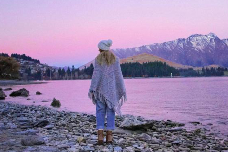 Girl walking on rocky shore