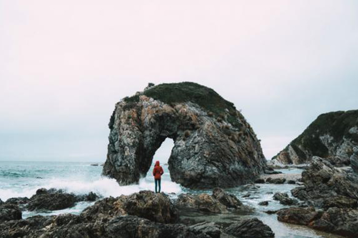 Woman standing on rocks at sea