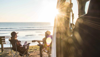 playing guitar on beach with parked compass