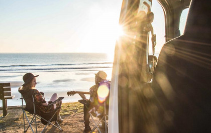 playing guitar on beach with parked compass