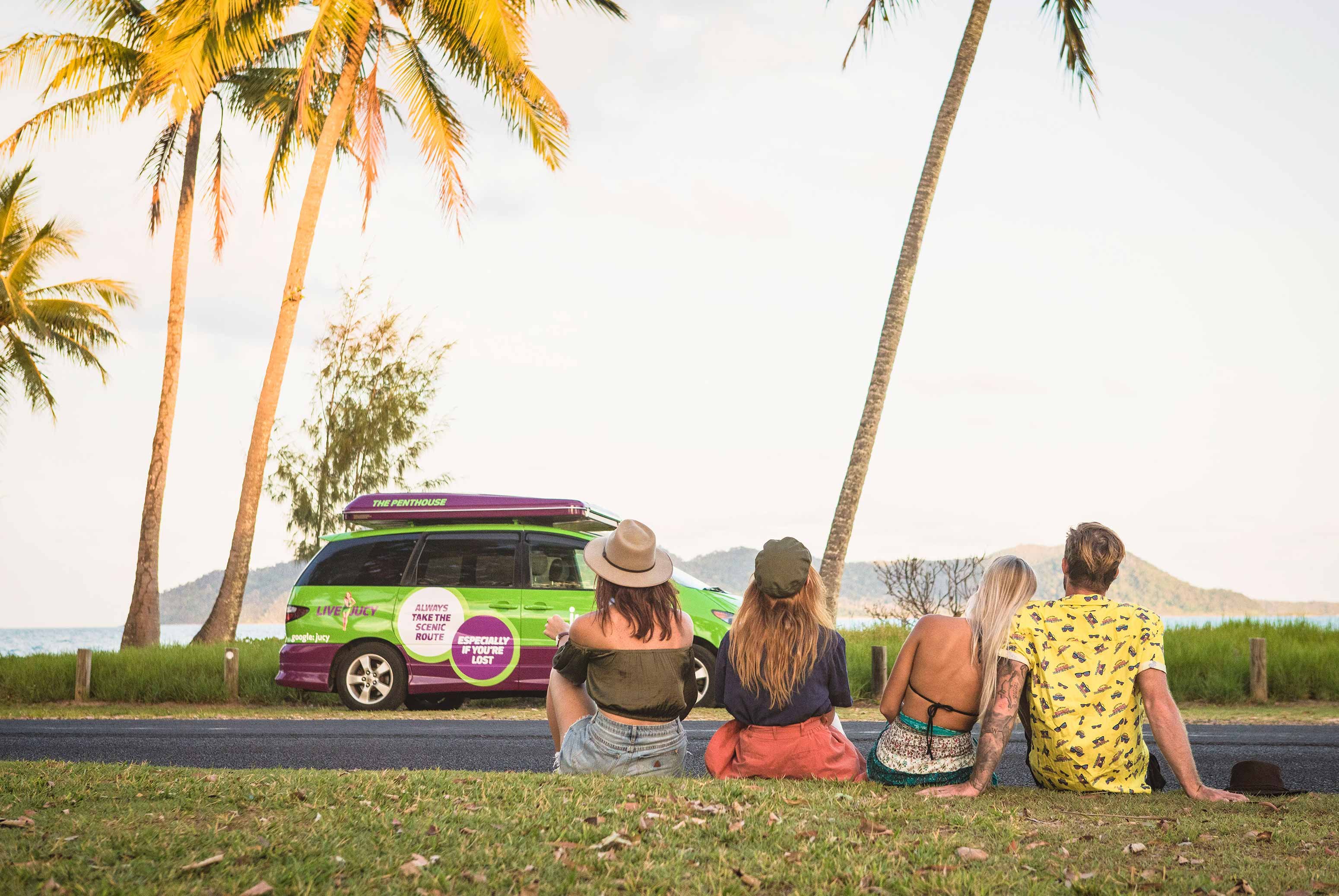 four friends sitting in beach side park champ