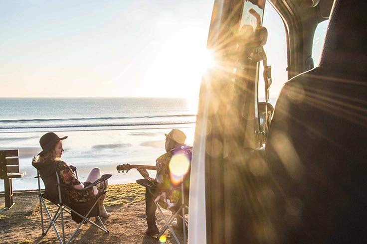 playing guitar on beach with parked compass